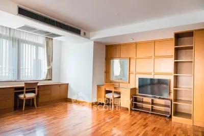 Spacious living room with wooden flooring and built-in furniture, perfect for modern living.
