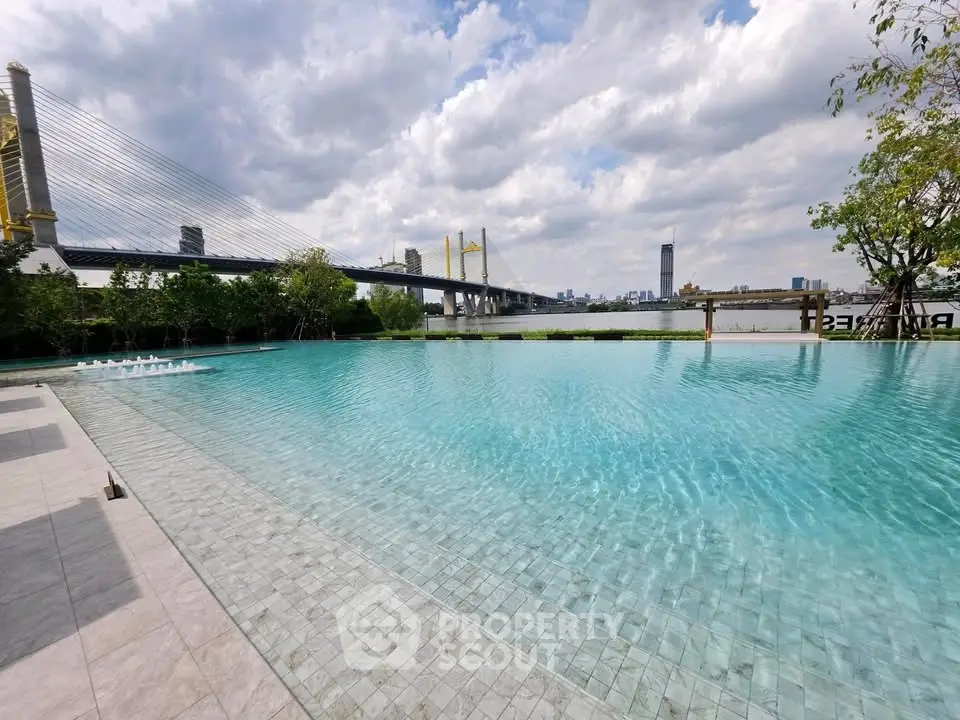 Luxurious infinity pool with stunning city skyline and bridge view, perfect for relaxation and leisure.