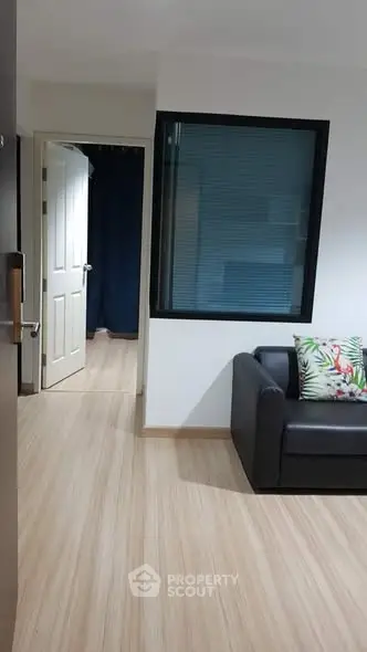 Modern apartment interior with sleek wooden flooring and cozy seating area.