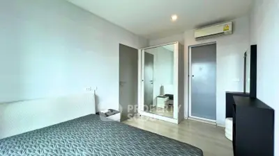 Modern bedroom with sleek design, featuring a mirrored wardrobe and air conditioning for comfort.