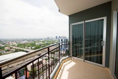 Spacious balcony with stunning city view in modern high-rise apartment.