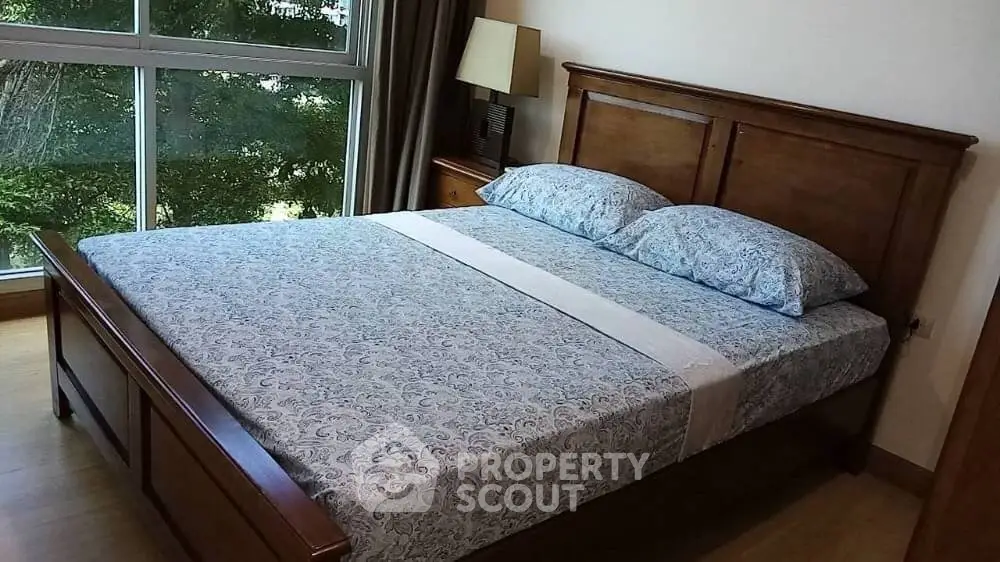 Cozy bedroom with wooden bed frame and large window view