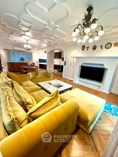 Luxurious living room with elegant chandelier and plush yellow sofa in a stylish apartment.
