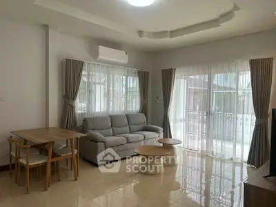 Spacious living room with modern furniture and large windows offering natural light.