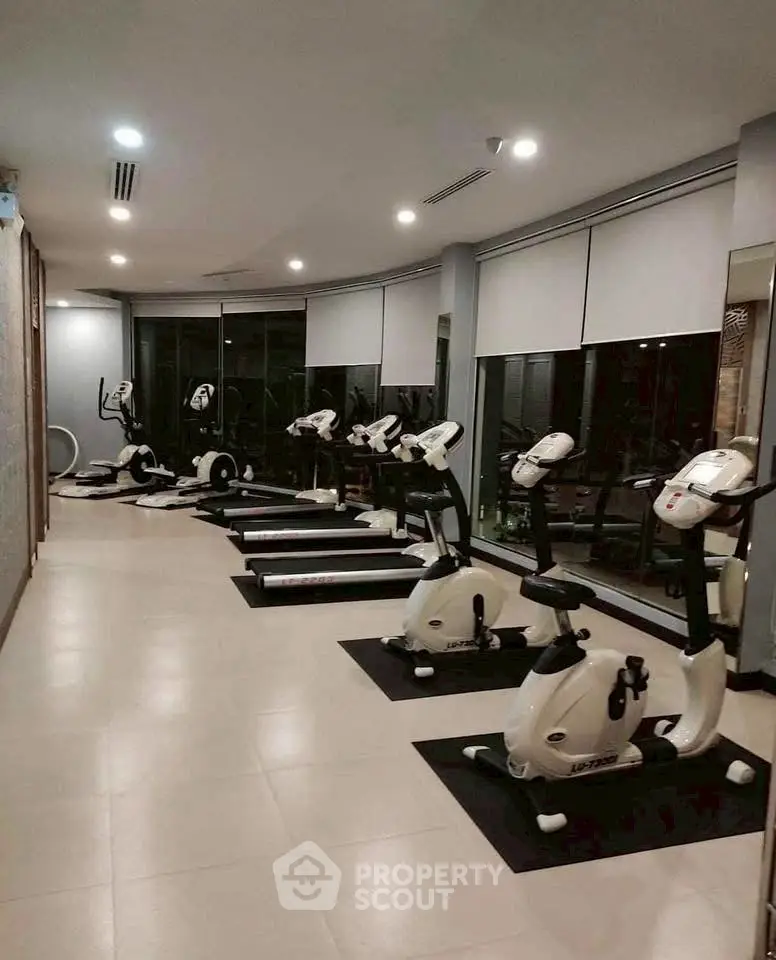 Modern gym with exercise bikes and treadmills in a sleek fitness center.
