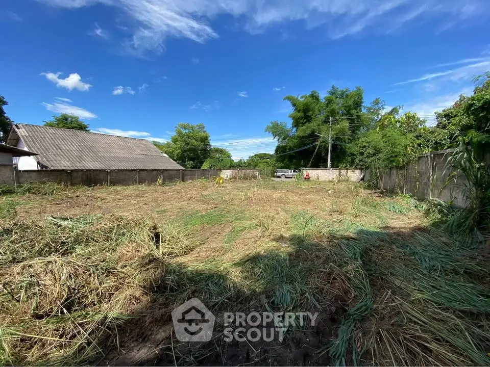 Spacious vacant land plot with clear blue sky, ideal for development opportunities.