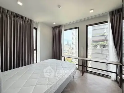 Modern bedroom with large windows offering stunning city views in a high-rise apartment.