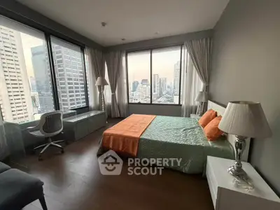 Spacious bedroom with city view, modern decor, and large windows in a high-rise apartment.