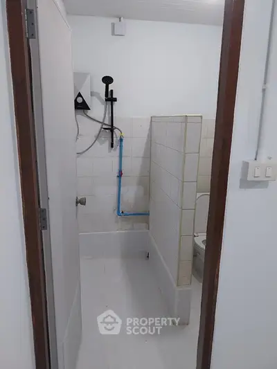 Compact bathroom with tiled walls and basic fixtures