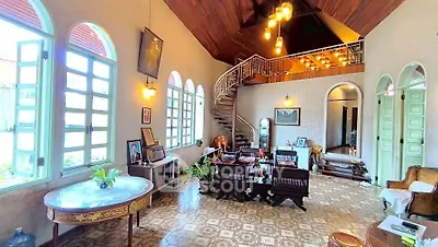 Charming vintage living room with high ceilings and elegant staircase