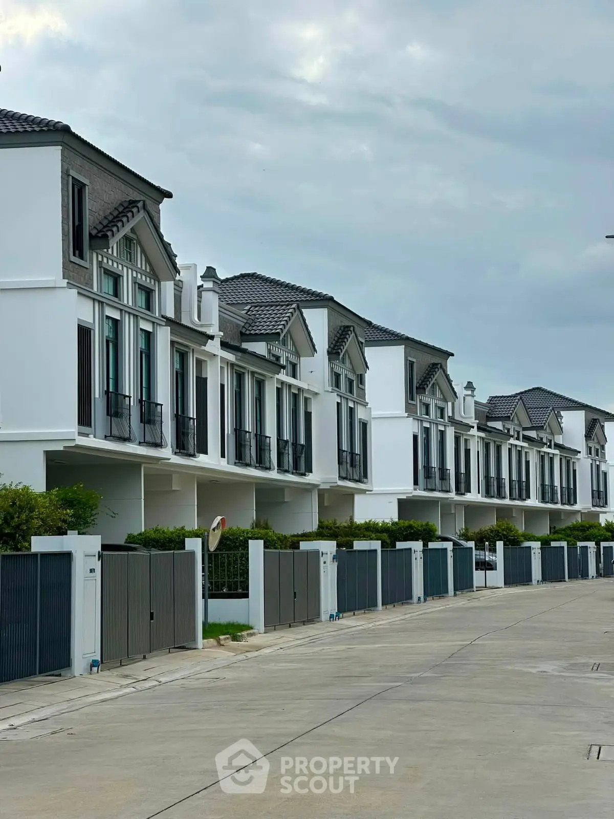 Elegant row of modern townhouses with stylish architecture and gated driveways in a serene neighborhood.