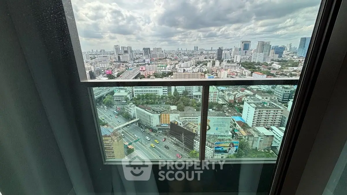 Stunning cityscape view from high-rise balcony with expansive skyline and bustling streets below.