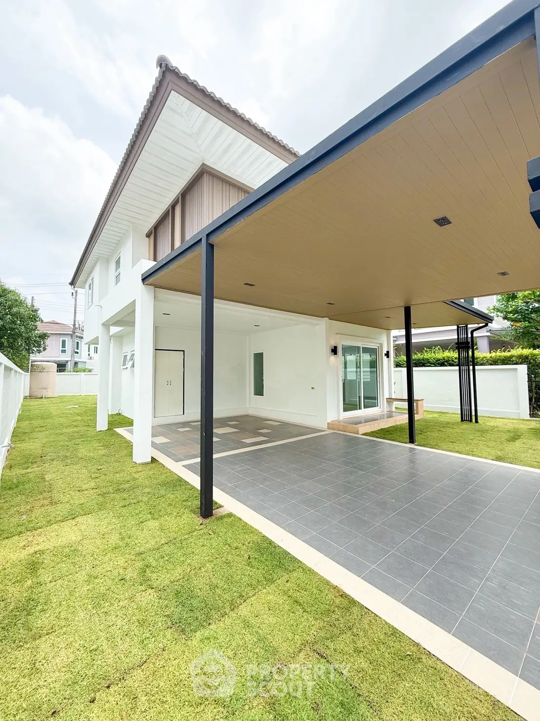 Modern two-story house with spacious carport and lush green lawn