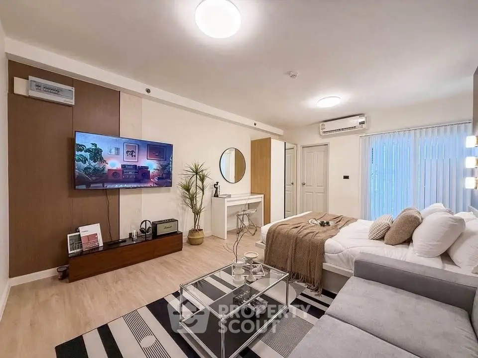 Modern living room with stylish decor, cozy seating, and large TV, perfect for relaxation and entertainment.