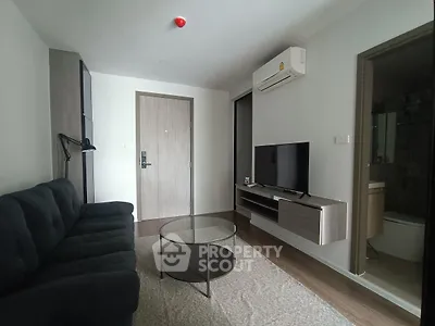 Modern living room with sleek furniture and wall-mounted TV in a cozy apartment.