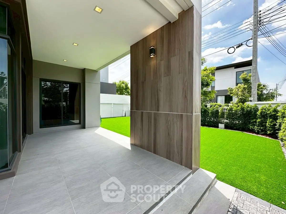 Modern home exterior with spacious patio and lush green lawn