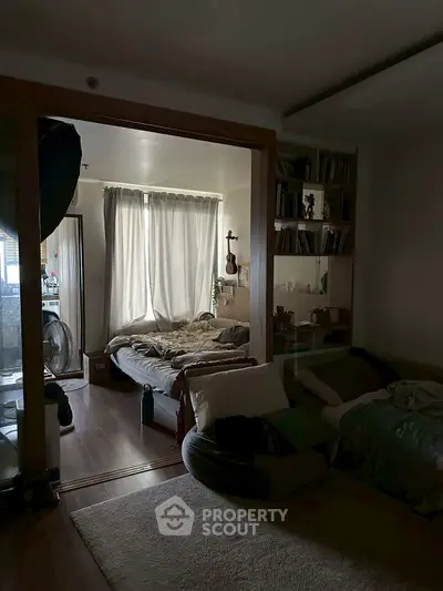 Cozy bedroom with natural light, wooden flooring, and modern decor, perfect for relaxation and comfort.