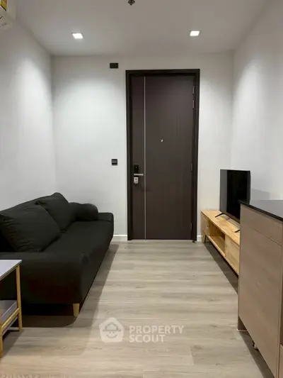 Modern living room with sleek black sofa and wooden TV stand