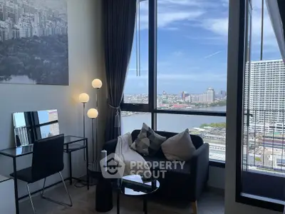 Modern living room with stunning city and river view, featuring sleek furniture and floor-to-ceiling windows.
