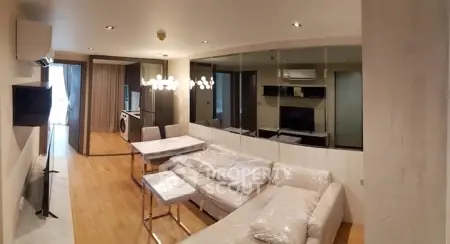 Modern living room with stylish furniture and open layout, featuring a washing machine and elegant lighting.
