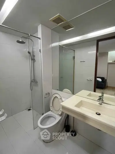 Modern bathroom with glass shower and sleek fixtures in a contemporary apartment.