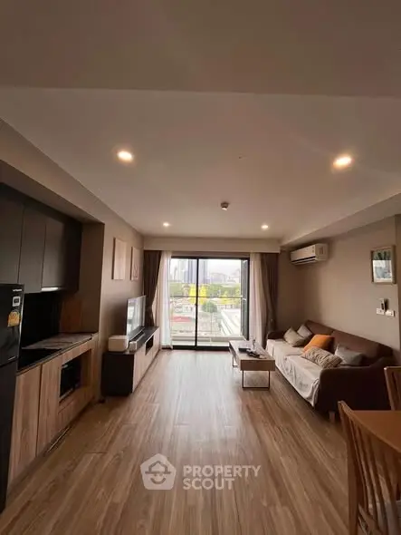 Spacious modern living room with large windows and stylish decor in a high-rise apartment.