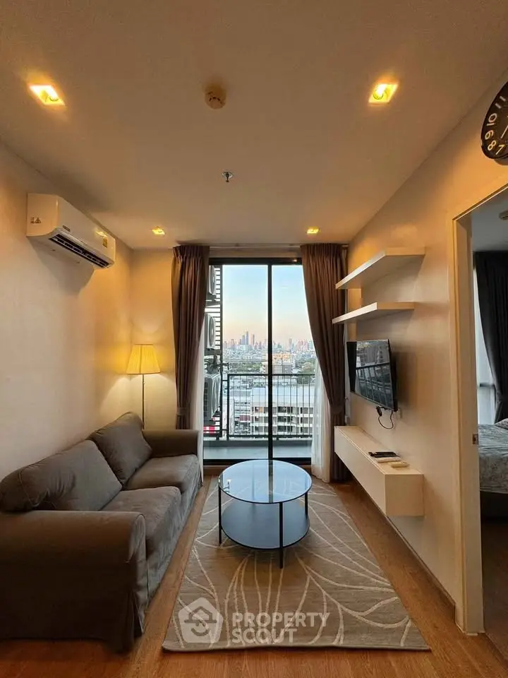 Modern living room with city view, featuring sleek furniture and natural light.