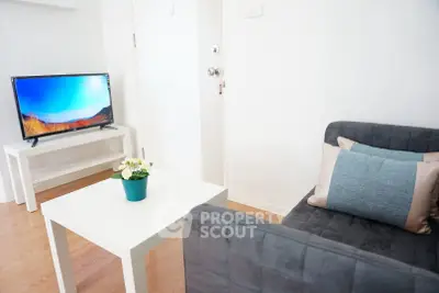 Modern living room with sleek furniture and flat-screen TV, perfect for relaxation.