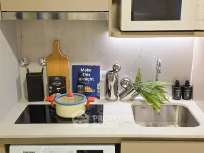 Modern kitchen with sleek design, featuring induction cooktop, microwave, and stylish decor.