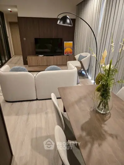 Modern living room with stylish furniture and elegant decor, featuring a cozy seating area and a sleek dining table.
