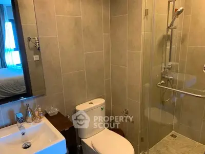 Modern bathroom with glass shower and sleek fixtures in a contemporary home.