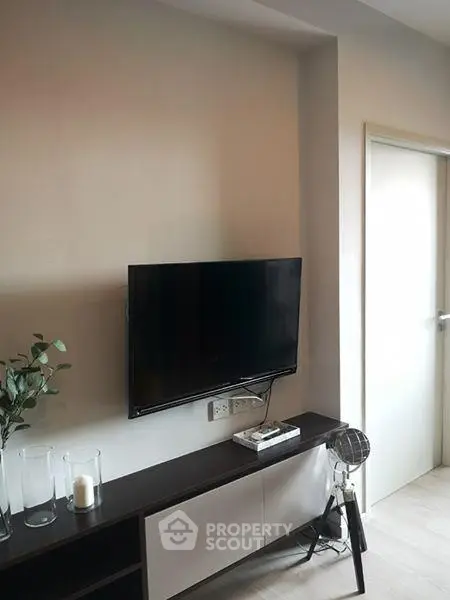 Modern living room with wall-mounted TV and sleek furniture design.