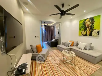 Modern living room with stylish decor and vibrant artwork, featuring cozy seating and a ceiling fan.