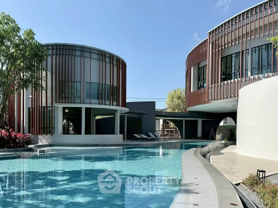Luxurious modern apartment complex with stunning pool and unique architectural design.