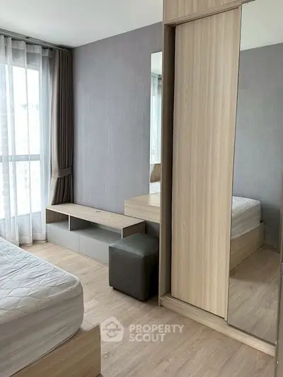 Modern bedroom with large window and stylish wooden furniture