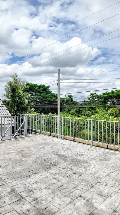 Spacious balcony with scenic view of lush greenery and clear skies, perfect for relaxation.