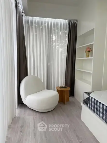 Modern minimalist room with cozy chair and natural light