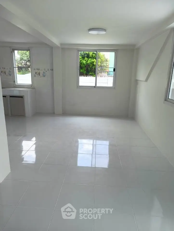 Spacious and bright living room with large windows and tiled flooring, perfect for modern living.