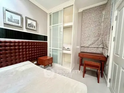 Cozy bedroom with stylish leather headboard and built-in wardrobe in modern apartment.
