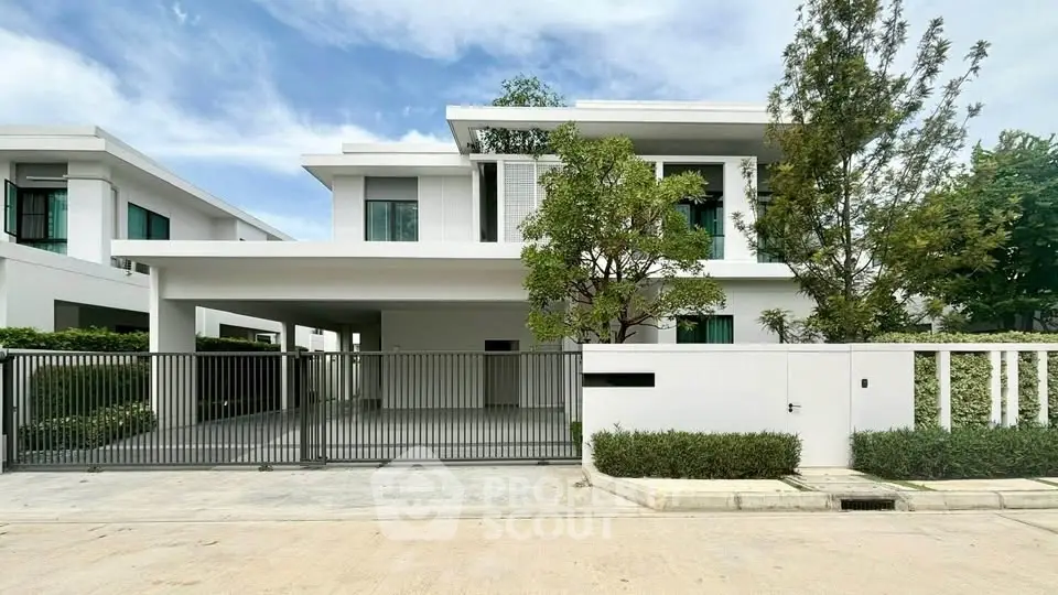 Modern two-story white house with sleek design and spacious driveway in a serene neighborhood.