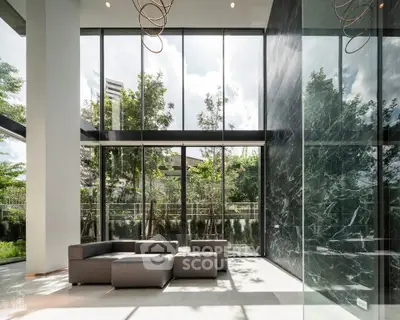 Luxurious modern living room with floor-to-ceiling windows and elegant marble accents.