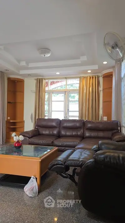 Spacious living room with leather sofas and elegant decor, perfect for relaxation and entertainment.