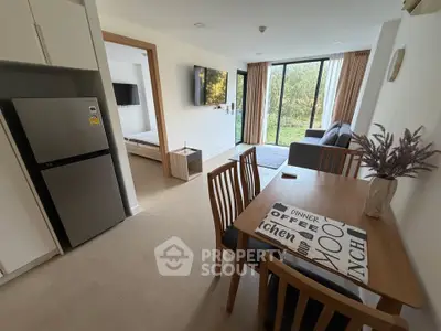 Modern open-plan living room with dining area and large windows overlooking greenery.