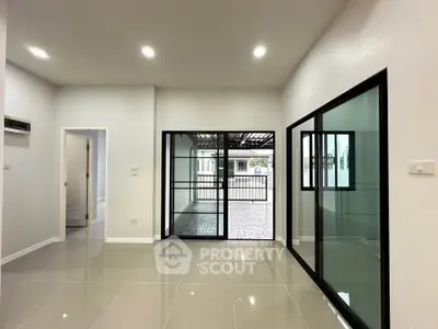 Modern living room with sleek glass doors and polished tile flooring