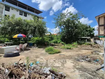 Spacious outdoor area with potential for development, featuring greenery and open space under a clear blue sky.