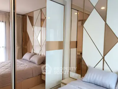 Modern bedroom with stylish mirrored wardrobe and cozy bedding in a contemporary apartment.