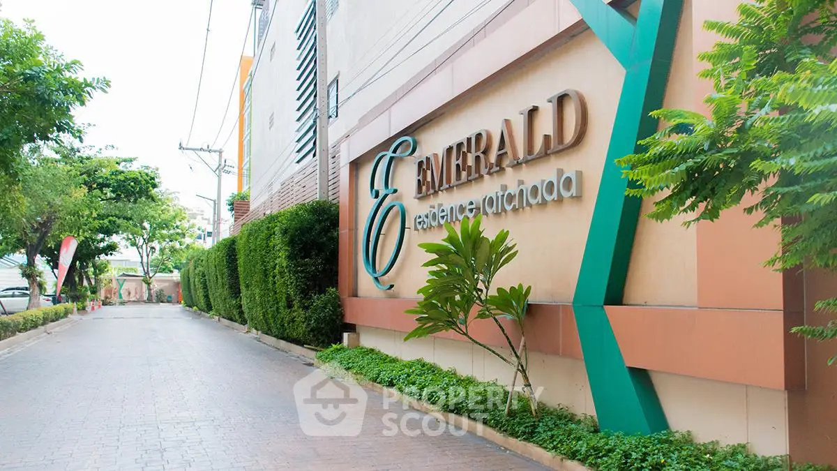 Elegant entrance of Emerald Residences with lush greenery and modern design.