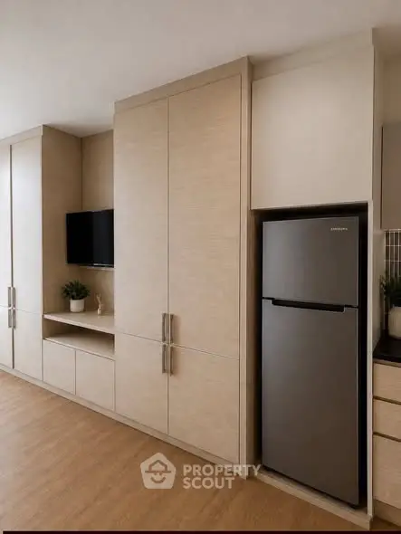 Modern kitchen with sleek cabinetry and stainless steel fridge in stylish apartment.