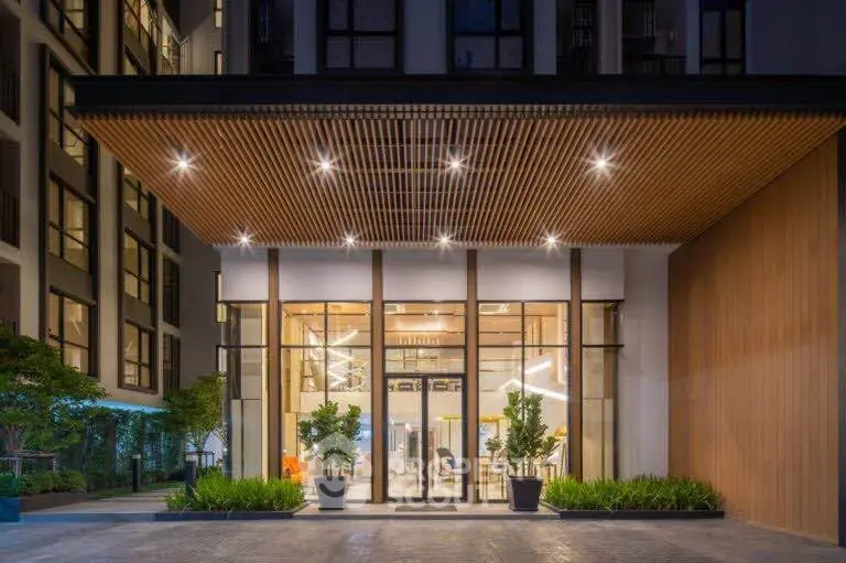Modern building entrance with stylish wooden ceiling and glass facade, showcasing contemporary architecture.