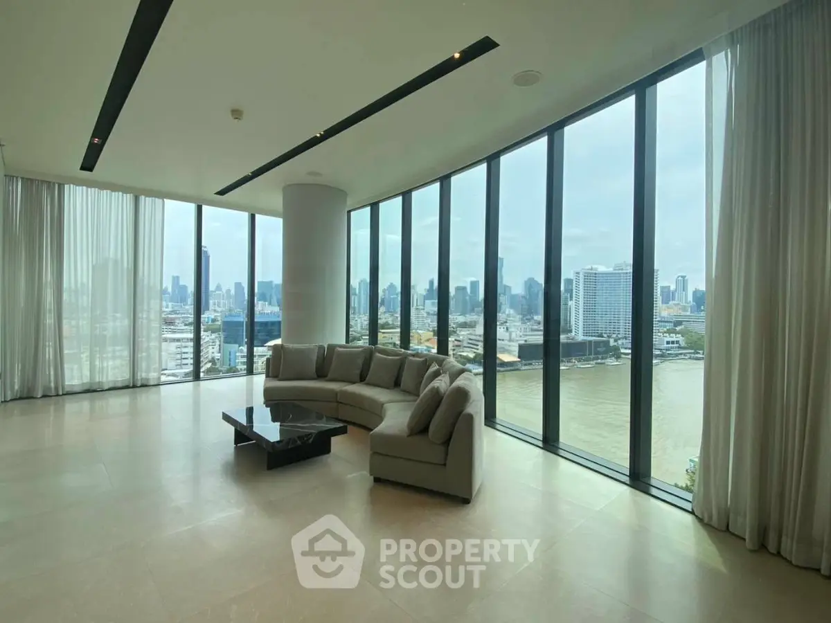 Luxurious corner unit living room with panoramic city and river views, featuring modern design and floor-to-ceiling windows.